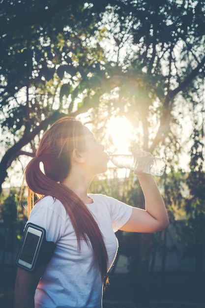 Fitness mujer hermosa agua potable y sudoración después de hacer ejercicio