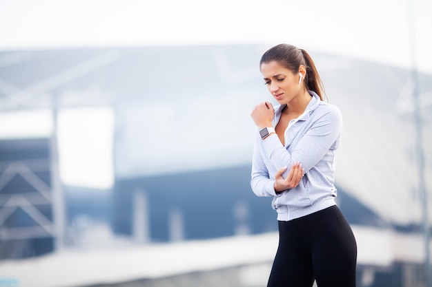 Fitness, la mujer tiene una lesión accidental y se lastima en los brazos mientras hace ejercicio en el concepto de dolor muscular al aire libre