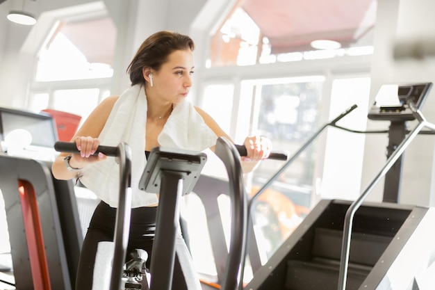 Fitness mujer trabaja en bicicleta de aire en el gimnasio moderno