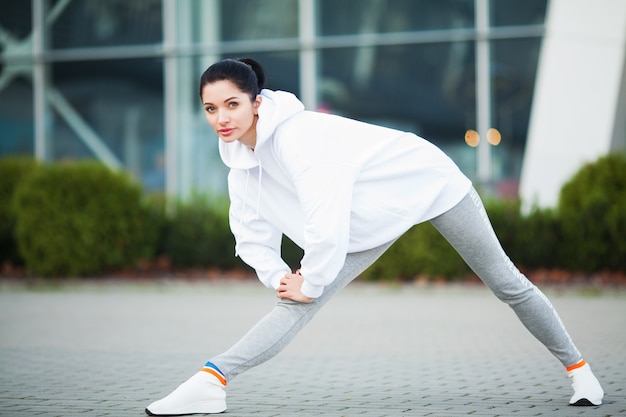 Fitness, mulher jovem e bonita fazendo exercícios no parque