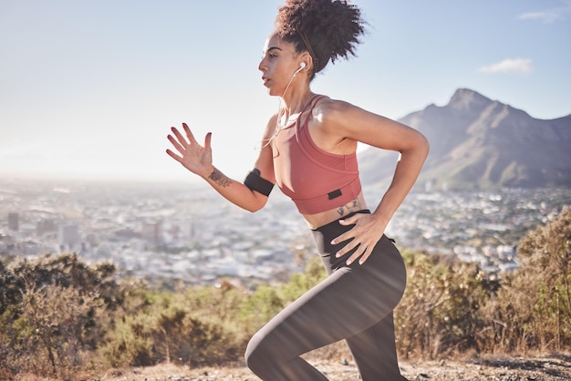 Fitness musical y mujer corriendo a lo largo de la montaña escuchando la radio mientras hace ejercicio y bienestar cardiovascular matutino Podcast deportivo y mujer negra enfocada en entrenar correr y hacer ejercicio con energía