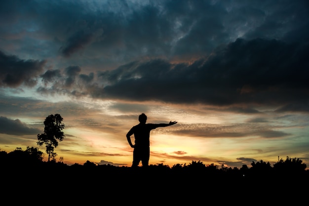 Foto fitness no nascer do sol da silhueta o conceito de bem-estar do garoto.