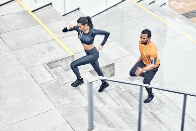 Fitness oben und laufendes Paar auf Treppen zum Training von Gesundheitsübungen und Sport in der Stadt Gesunder Lebensstil und Mann und Frau mit Schwerpunkt Musik und Energie für Outdoor-Cardio auf Stufen in Frankreich