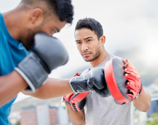 Fitness-Personaltrainer und Boxübungen für sportliches Wettkampftraining oder Selbstverteidigungsübungen in der Stadt Boxer beim intensiven Krafttraining mit Trainer zur Vorbereitung auf den Wettkampfkampf