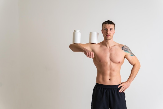 Fitness-Protein-Gläser weiß auf weißem Hintergrund Bodybuilder-Pulver starker hoher Körper schmerzhafter Krampf