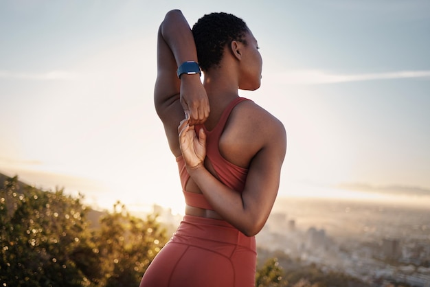 Fitness schwarze Frau und Stretching Arm auf dem Berg in Kapstadt für Muskel-Wellness gesunde Ziele und Energie