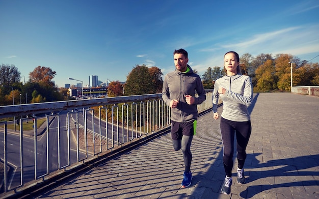 Fitness, Sport, Menschen und Lebensstil - ein glückliches Paar, das im Freien läuft