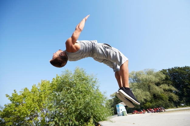 Fitness-, Sport-, Parkour- und People-Konzept - junger Mann springt im Sommerpark