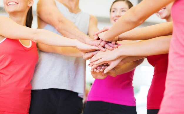 Fitness-, Sport-, Trainings-, Fitness-, Erfolgs- und Lifestyle-Konzept - Gruppe glücklicher Menschen im Fitnessstudio, die den Sieg feiern