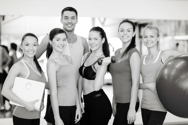 Foto fitness-, sport-, trainings-, fitness- und lifestyle-konzept - gruppe lächelnder menschen im fitnessstudio