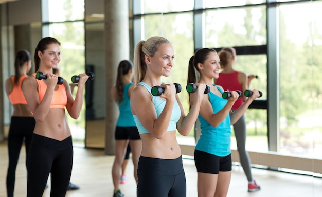 Fitness-, Sport-, Trainings-, Fitness- und Lifestyle-Konzept - Gruppe von Frauen mit Hanteln im Fitnessstudio