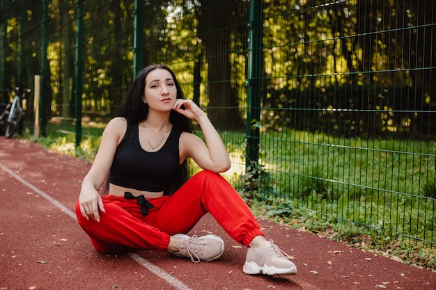 Foto fitness-sportmädchen in der modesportbekleidung, die yoga-fitnessübung auf der straße, im freien, im städtischen stil tut