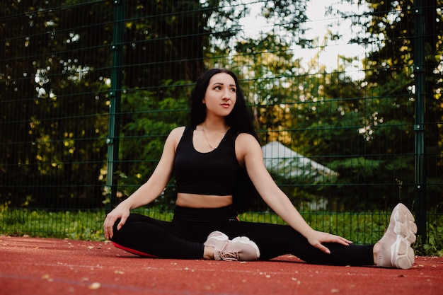 Foto fitness-sportmädchen in der modesportbekleidung, die yoga-fitnessübung auf der straße, im freien, im städtischen stil tut