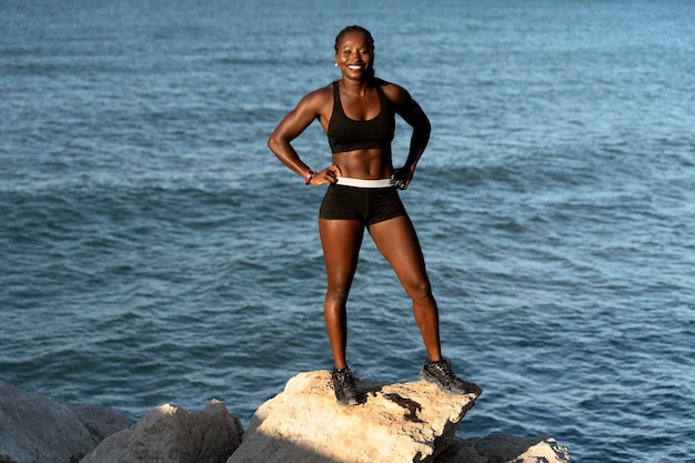 Fitness-Sportmodell lächelt glücklich nach dem Training im Freien an einem sonnigen Sommertag