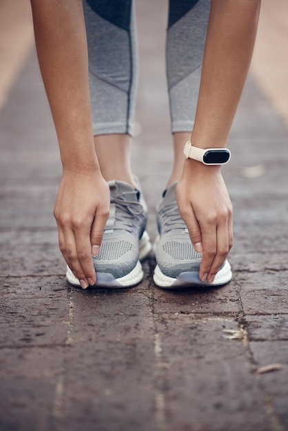 Foto fitness-stretching und frau mit schuhen und zehen berühren sich mit smartwatch für workout-gesundheits- und sporttraining. trainieren sie wellness und leistung mit den händen des athleten für den cardio-lifestyle im freien