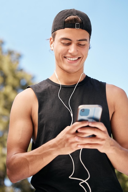 Fitness-Telefon und Mann in den sozialen Medien für eine Meme-Internetunterhaltung oder trendige Online-Inhalte im Freien Lächeln Sie einen glücklichen und gesunden Athleten, der eine SMS schreibt, postet oder eine lustige Nachricht in einer coolen App eingibt