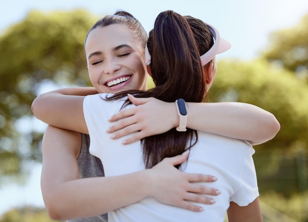 Fitness-Umarmung und Freunde im Park oder im Freien mit unterstützender Sorgfalt und Liebe zum Training, Cardio-Training und Wellness-Ziel Sportler, die sich mit Feier umarmen oder sich für den Fortschritt der Frauenübungen bedanken