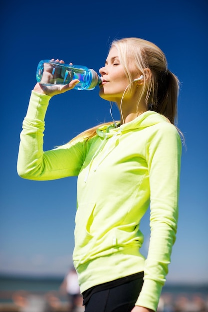 Fitness- und Lifestyle-Konzept - Frau trinkt Wasser nach Sport im Freien