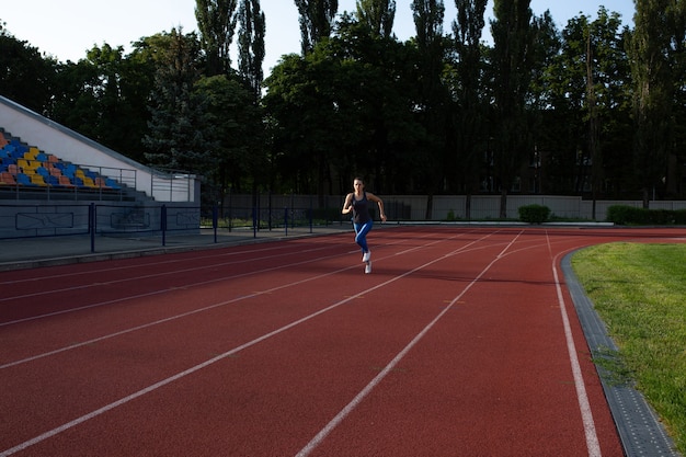 Fitnessfrau läuft abends im leeren Stadion