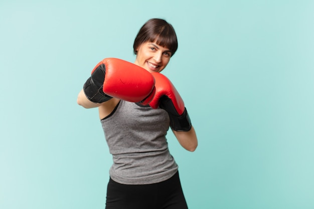 Fitnessfrau mit roten Boxhandschuhen.