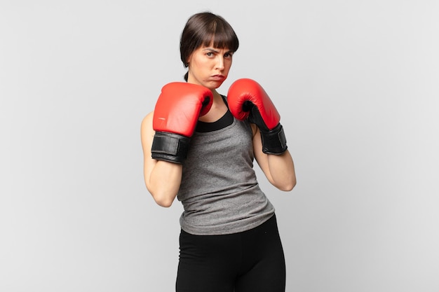 Fitnessfrau mit roten Boxhandschuhen.