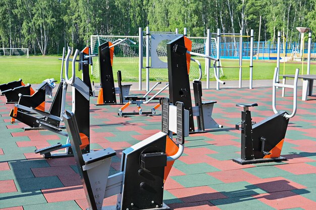 Foto fitnessgeräte im freien, sportstadion oder sportplatz, leeres trainingszentrum, draußen, keine menschen, sommersportkonzept, straßentraining, fitnessstudio, öffentlicher sportplatz