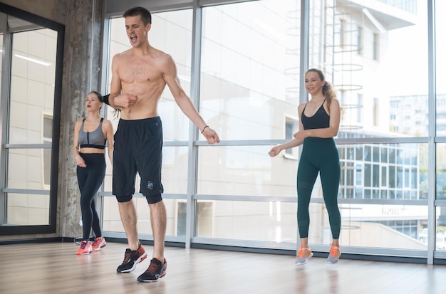 Fitnesstraining im Studio Zwei junge Frauen trainieren mit ihren Trainer-Sprungübungen