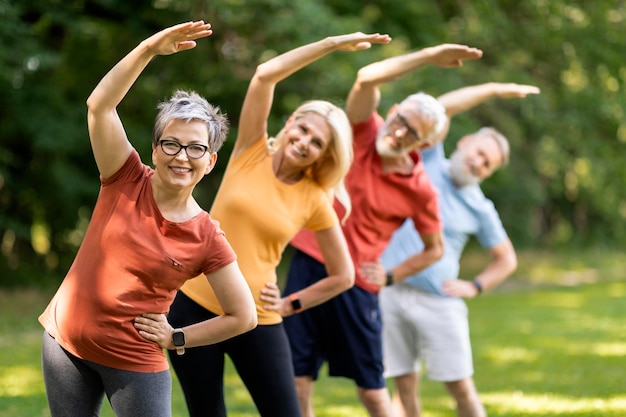 Foto fitnessübungen für senioren, sportliche, reife menschen, die gemeinsam im freien trainieren