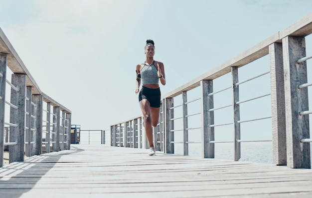 Fitnessübungen und Laufen mit schwarzer Frau auf Brücke mit morgendlichem Training für Sportgesundheit und Wellness Motivationsfreiheit und Energie mit Läufertraining für Marathonziele und Vision