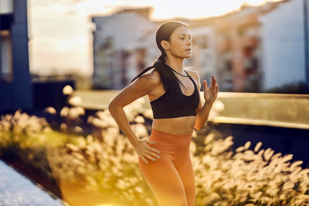 Fitte Sportlerin läuft im urbanen Äußeren an Ort und Stelle