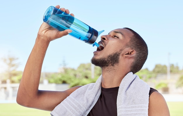 Fitter, aktiver, sportlicher Mann, der eine Pause vom Training einlegt, um zu hydratisieren und zu erfrischen