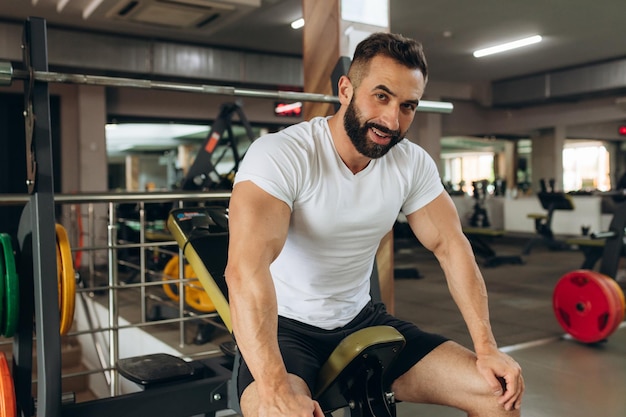 Fitter Mann, der eine Pause vom Training im Fitnessstudio macht