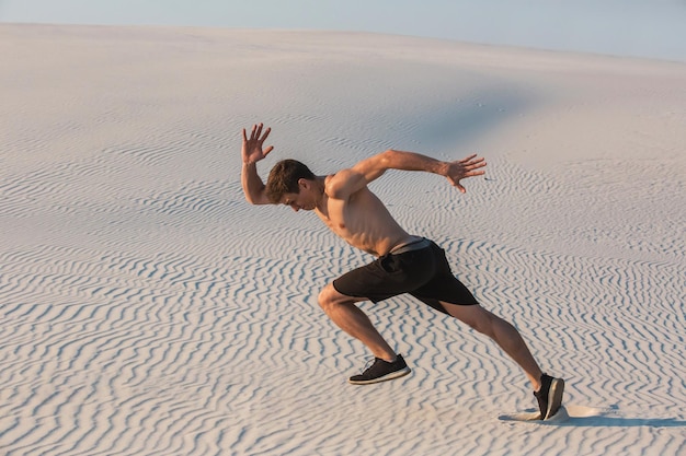 Fitter Mann, der schnell auf dem Sand läuft. Leistungsstarkes Läufertraining im Sommer im Freien. Mann in Sportshorts