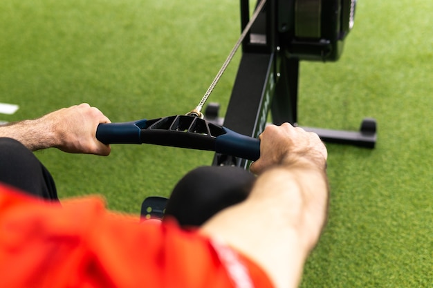 Foto fitter mann trainiert am rudergerät im fitnessstudio