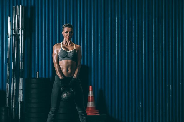 Foto fittes frauentraining beim heben der kettlebell im fitnessstudio