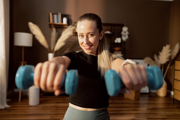 Fittes Mädchentraining, das Übungen macht, Sport drinnen mit Blick auf die Kamera