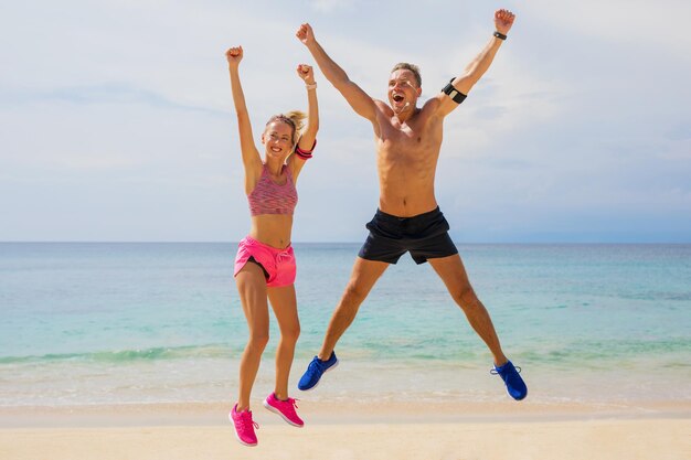 Fittes Paar, das sich nach dem absolvierten Training am Strand großartig fühlt