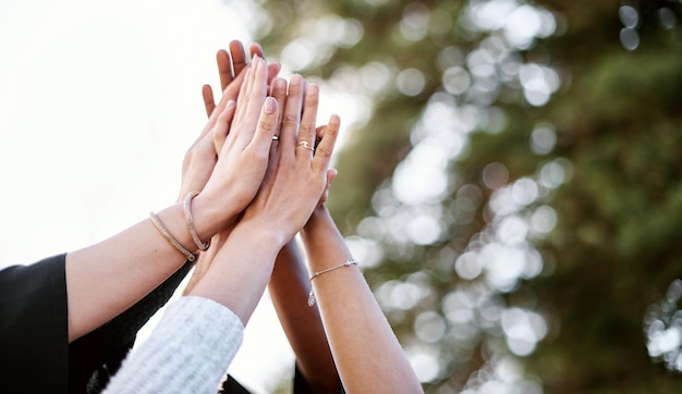 Fizemos isso Closeup shot de um grupo de estudantes dando um high five no dia da formatura