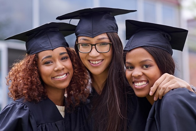 Fizemos isso juntos Foto recortada de três jovens no dia da formatura