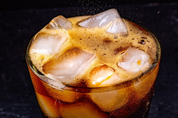 Foto fizz com água de cola com gás e refrigerante borbulhante com cubos de gelo.