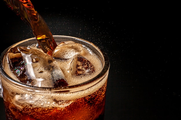 Foto fizz espumante cola água refrescante borbulhante soda pop com cubos de gelo. cola de refrigerante gelada carbonatada líquido fresco e fresco gelado em um copo. refrescante e sacie o conceito de sede.