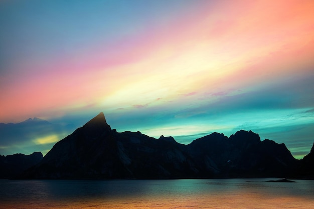 Fjord bei Sonnenuntergang Felsiger Strand am Abend Silhouette der Felsen gegen farbenprächtigen Sonnenuntergang Himmel Lofoten Reine Norwegen