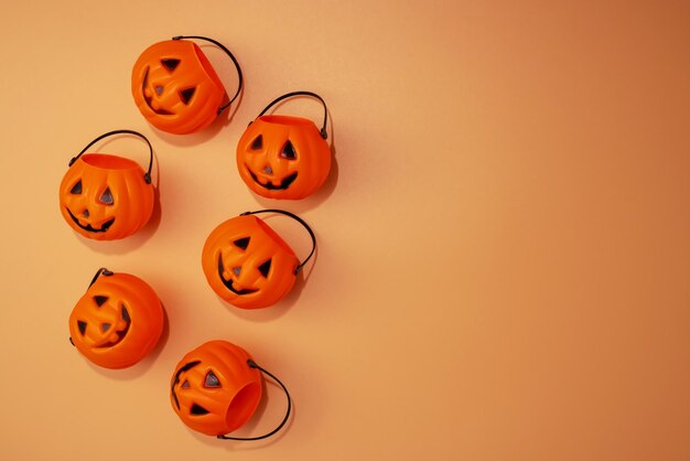 Flach gelegene Komposition mit Halloween-Trick-or-Treat-Eimer auf orangefarbenem Hintergrund
