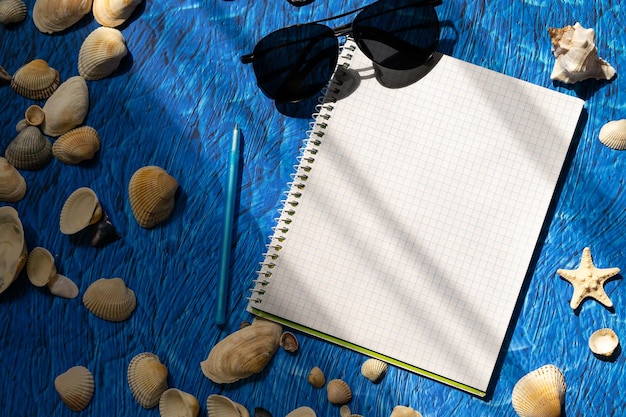 flach lag auf blauem Hintergrund leerer Notizbuch-Kopienraum. sommer plant konzept