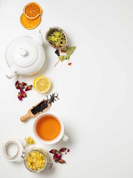 Foto flach lag eine tasse schwarzen tee, früchte- und kräutertee, mit zitrone und teekanne auf weißem hintergrund. das konzept eines gesunden getränks. draufsicht und kopierbereich.