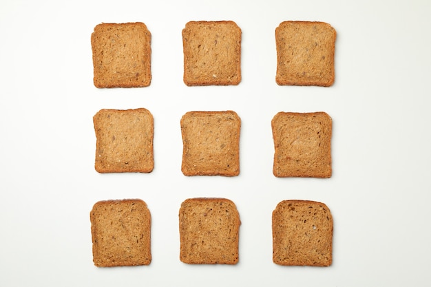 Flach lag mit dunklen Brotscheiben auf weißem Hintergrund