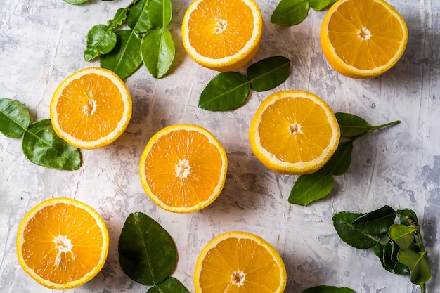 Flach legen Scheiben von rohen frischen Orangenfrüchten mit Blättern.