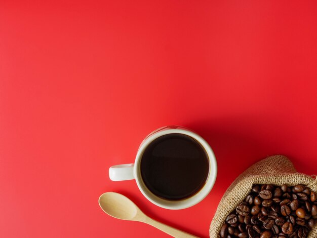 Flach legen Sie eine Tasse Kaffee auf rotem Schreibtisch mit Kopienraum