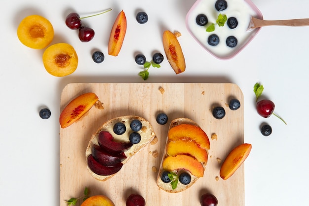 Flach legen Sie köstliche Früchte auf Holzbrett