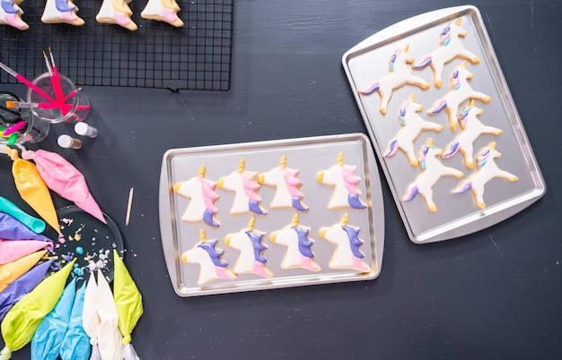 Flach liegen. Einhornförmige Zuckerkekse mit Royal Icing dekorieren.